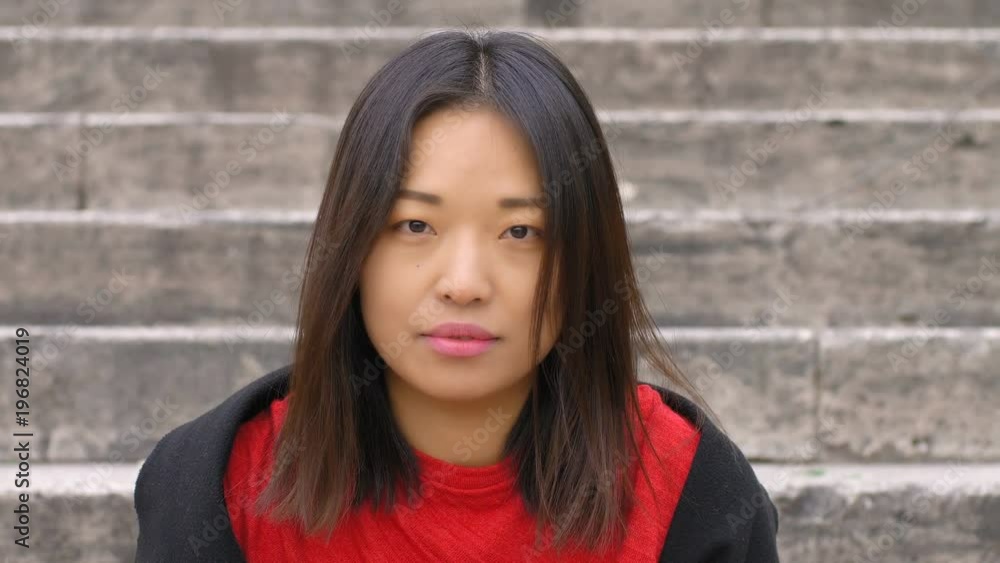 beautiful asian woman with close eyes opening and smiles at camera beautiful asian woman with close eyes opening and smiles at camera