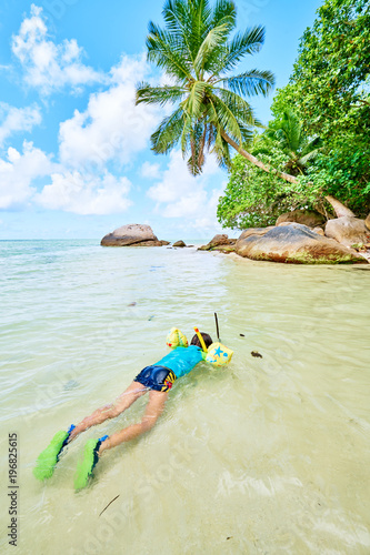 Fototapeta Naklejka Na Ścianę i Meble -  a little boy with mask and snorkel in the water in tropical beac