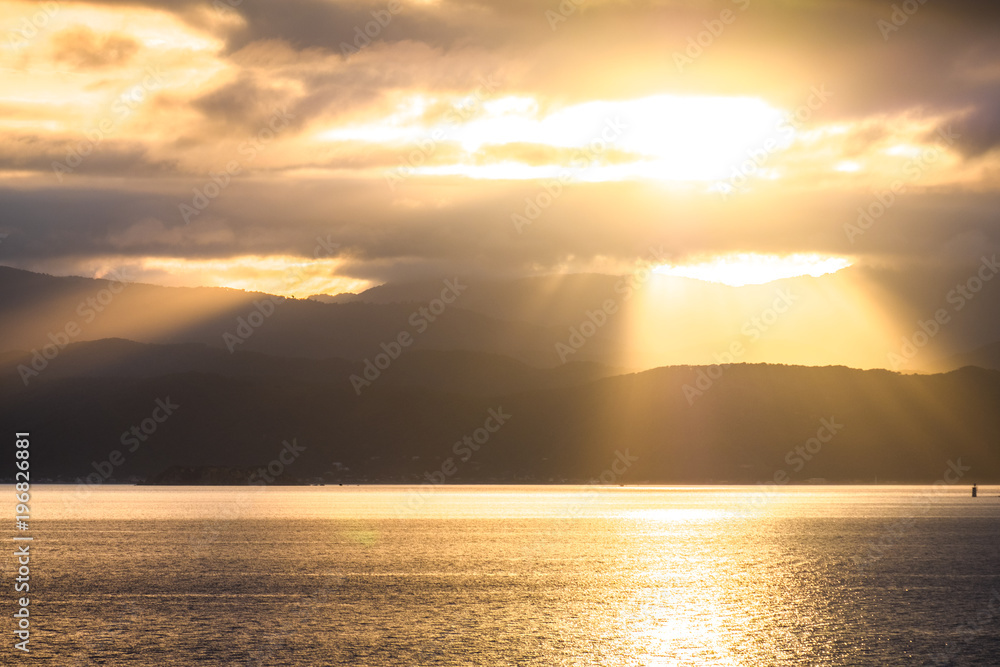 Obraz premium Stunning landscape sunrise in the morning. Golden light go through the cloud to the mountain and sea.