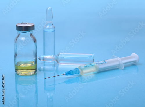 Syringe and Medical ampoules, vaccine on table.
