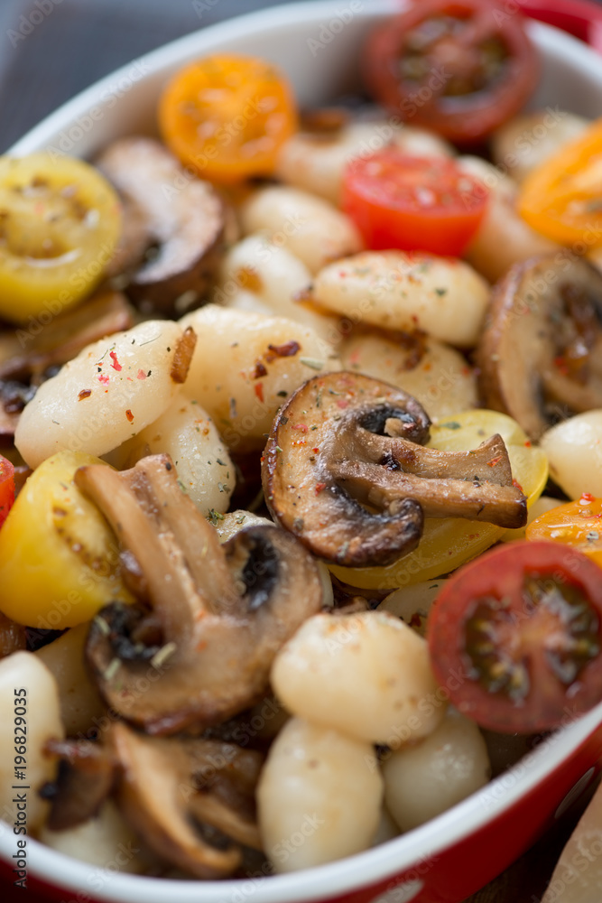 Close-up of boiled potato gnocchi with roasted mushrooms and fresh sliced tomatoes, selective focus Close-up of boiled potato gnocchi with roasted mushrooms and fresh sliced tomatoes, selective focus
