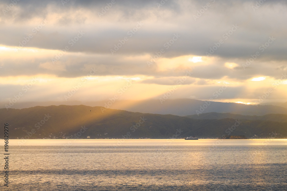 Fototapeta premium Stunning landscape sunrise in the morning. Golden light go through the cloud to the mountain and sea.