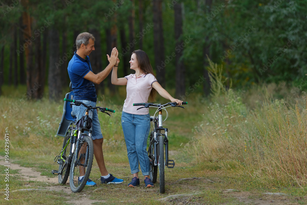 Happy couple with bikes funs in pine forest