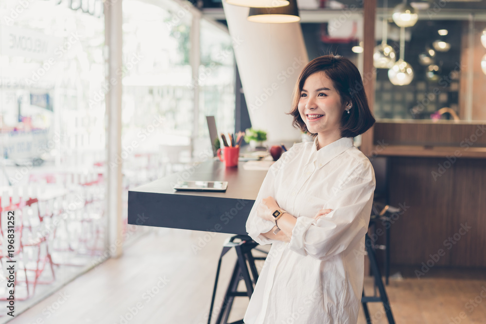 Beautiful business woman standing cross one's arm and smiling in coworking spaces. Beautiful business woman standing cross one's arm and smiling in coworking spaces.