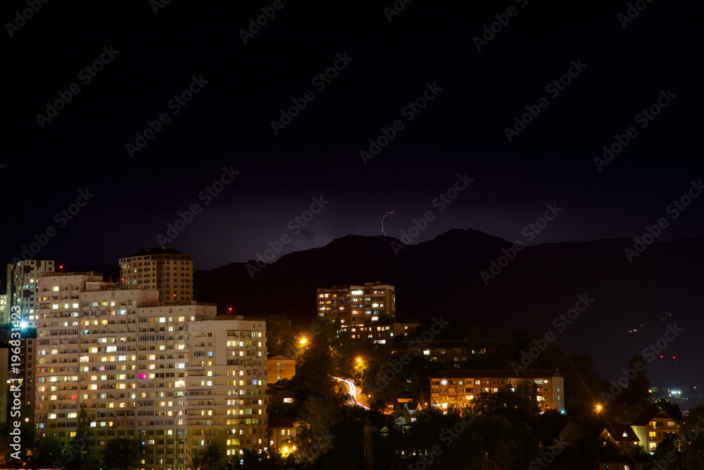 Lightning in the night sky in the mountains outside the city