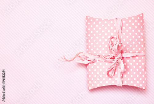 Festive gift on pink pastel background, present box for celebration card, selective focus, toned