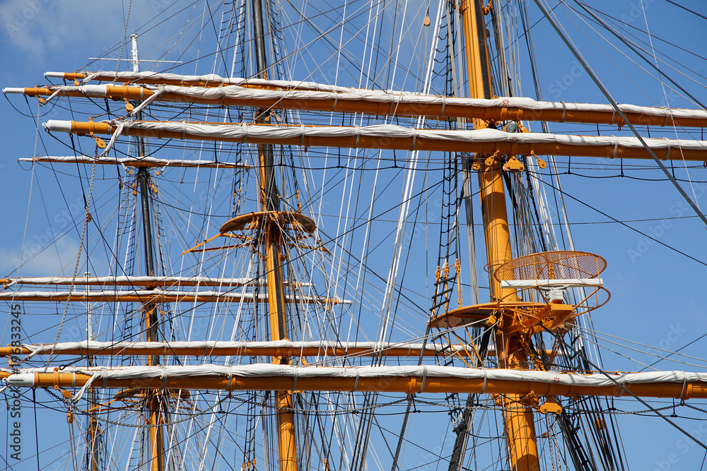 A sunny blue sky and a mast of a sailing ship