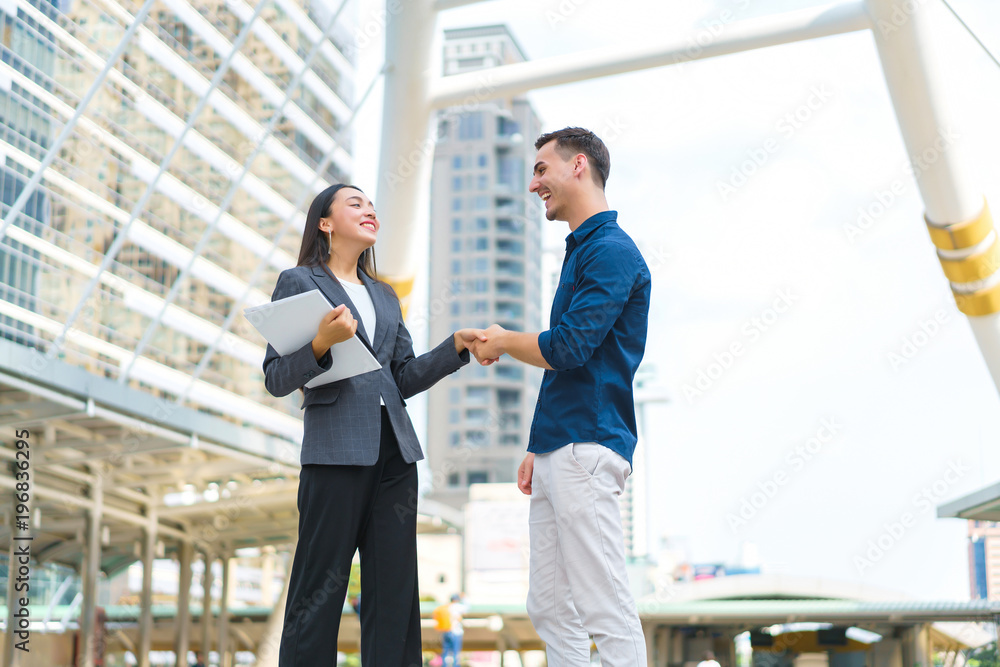 Beautiful asian businesswoman shaking hands with handsome man for success business solution. concept of communication, negotiation and business together. Beautiful asian businesswoman shaking hands with handsome man for success business solution. concept of communication, negotiation and business together.