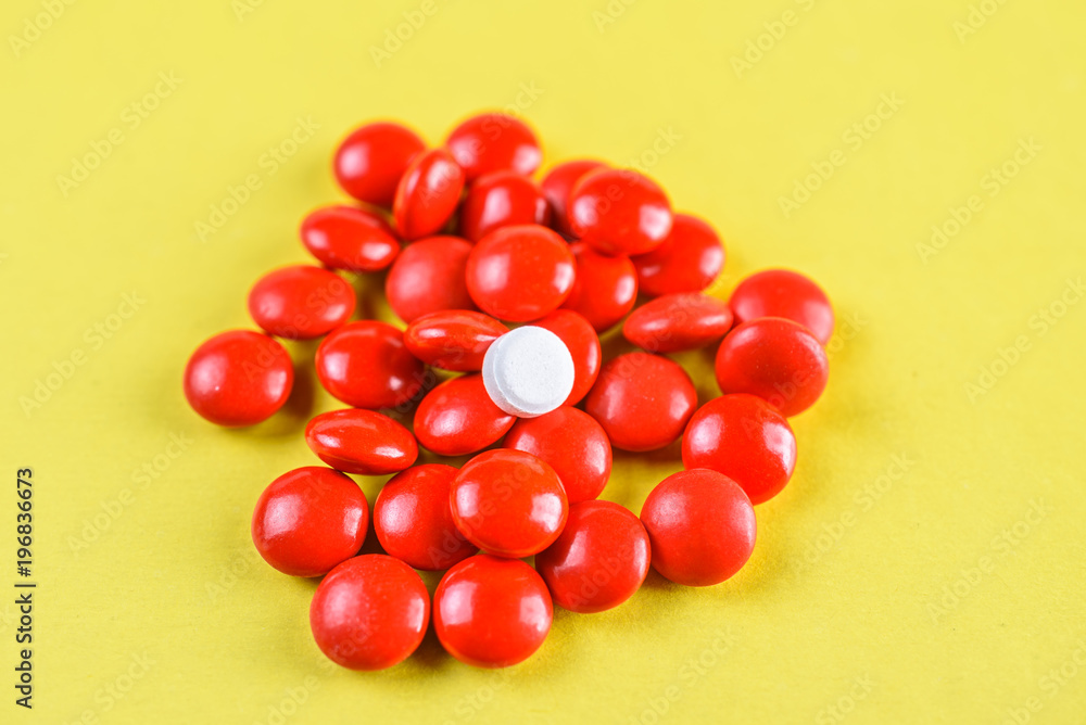 bright red pills on a yellow background. bright red pills on a yellow background.