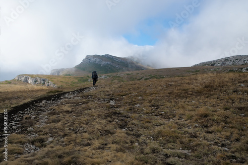 A tourist at the top Crimean Chatyr-Dag mountain in autumn