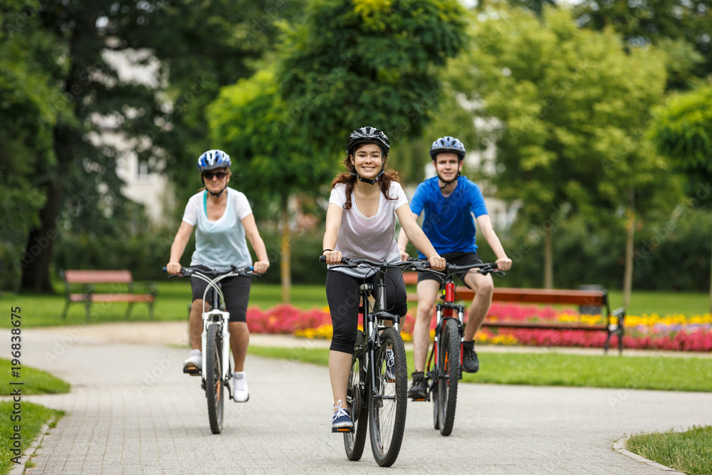 Naklejka premium Healthy lifestyle - people riding bicycles in city park 