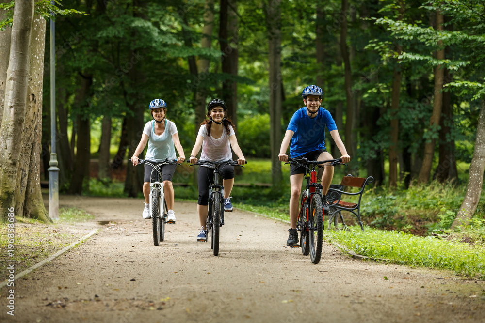 Healthy lifestyle - people riding bicycles in city park Healthy lifestyle - people riding bicycles in city park