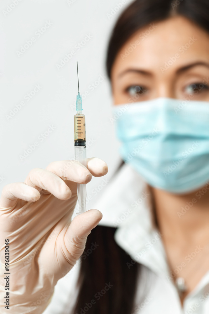 The cosmetician holds a syringe with a preparation The cosmetician holds a syringe with a preparation