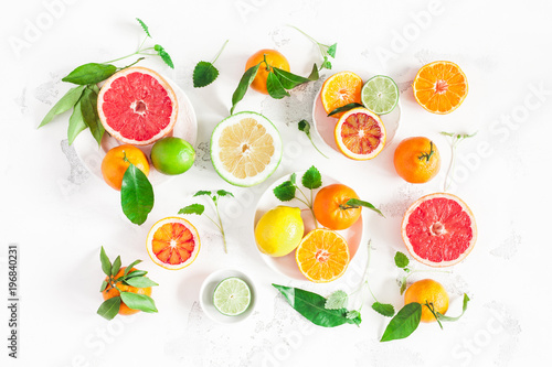 Fruit background. Colorful fresh fruits on white table. Orange  tangerine  lime  lemon  grapefruit. Flat lay  top view