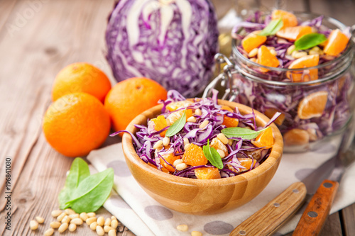 Red cabbage tangerines and pine nuts salad. Selective focus. Copy space.
