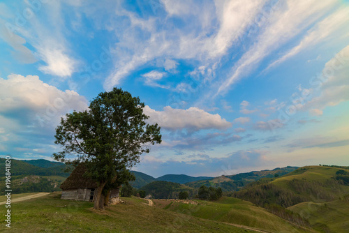 Beautiful mountain landscape with and old house, trees and a cloudy morning sky, Dumesti, Salciua, Apuseni, Romania