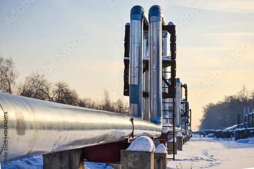 Overground heat pipes. Pipeline above ground, conducting heat for heating the city. Winter. Snow. photo