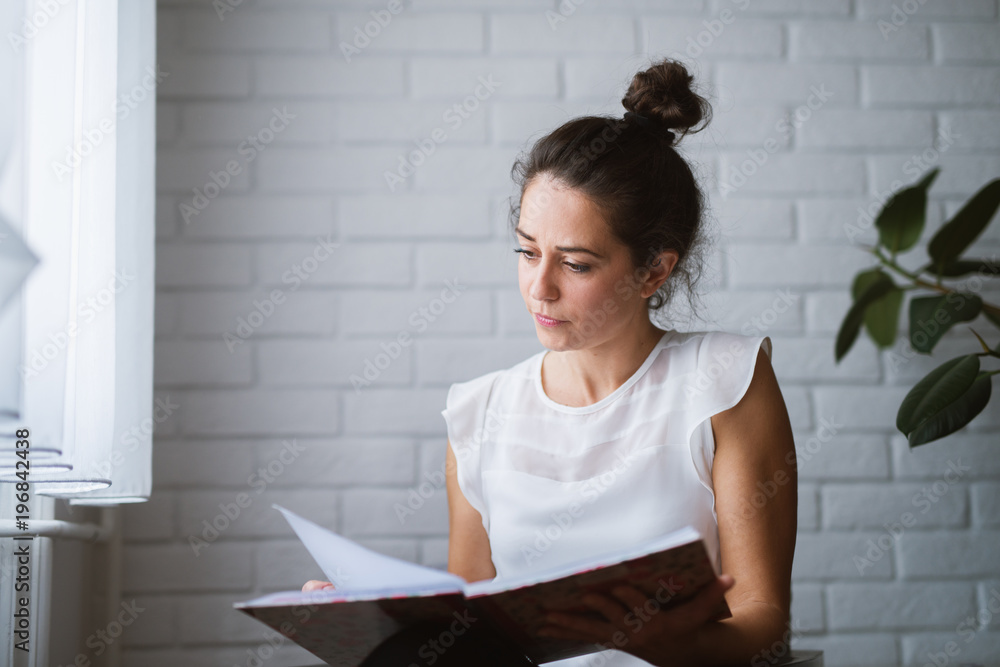 Woman at home holding notebook working business from home. Woman at home holding notebook working business from home.