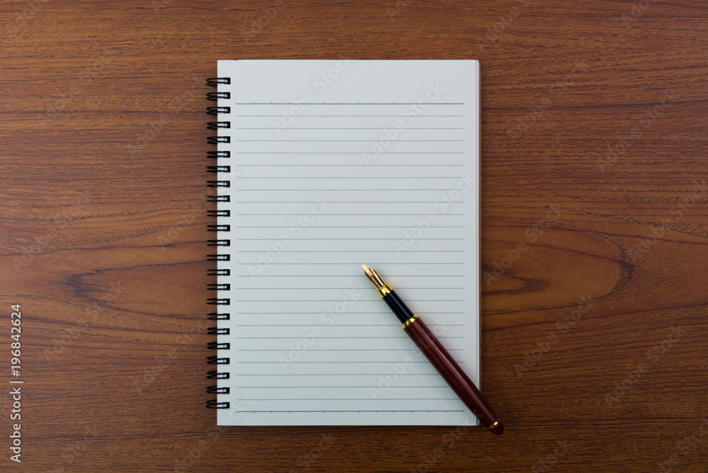 Fountain pen or ink pen with notebook paper on wooden working table with copy space, office desk concept. top view. Fountain pen or ink pen with notebook paper on wooden working table with copy space, office desk concept. top view.
