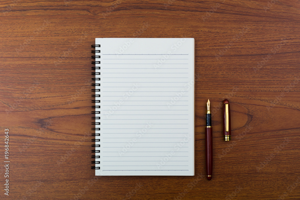 Fountain pen or ink pen with notebook paper on wooden working table with copy space, office desk concept. top view. Fountain pen or ink pen with notebook paper on wooden working table with copy space, office desk concept. top view.