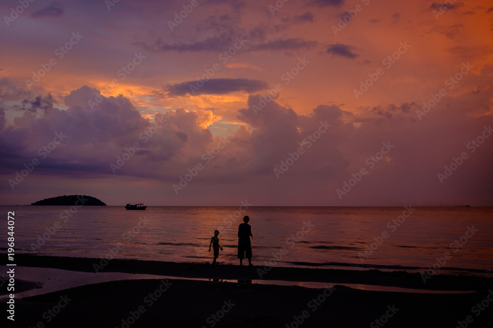Boy and mother walking on the beach at sunset, Sihanoukville, Cambodia