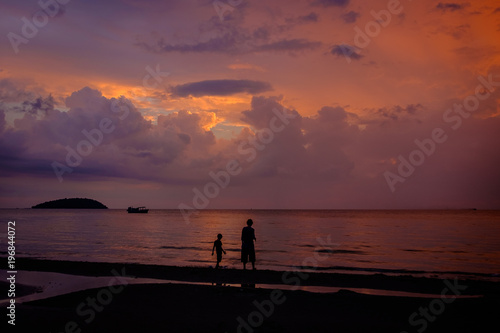 Boy and mother walking on the beach at sunset, Sihanoukville, Cambodia