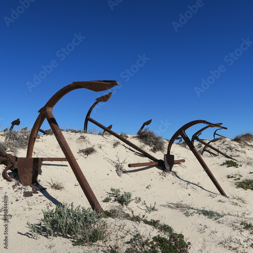 Old anchor in the dunes, tourist attraction at Faro, Portugal, Europe