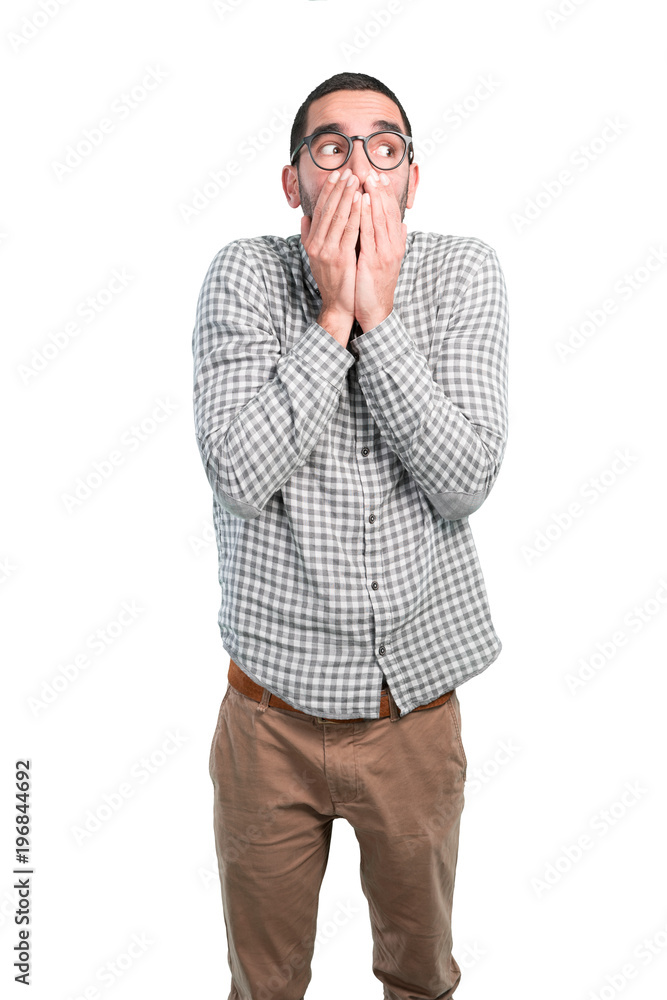 Worried young man covering his mouth with his hands Worried young man covering his mouth with his hands