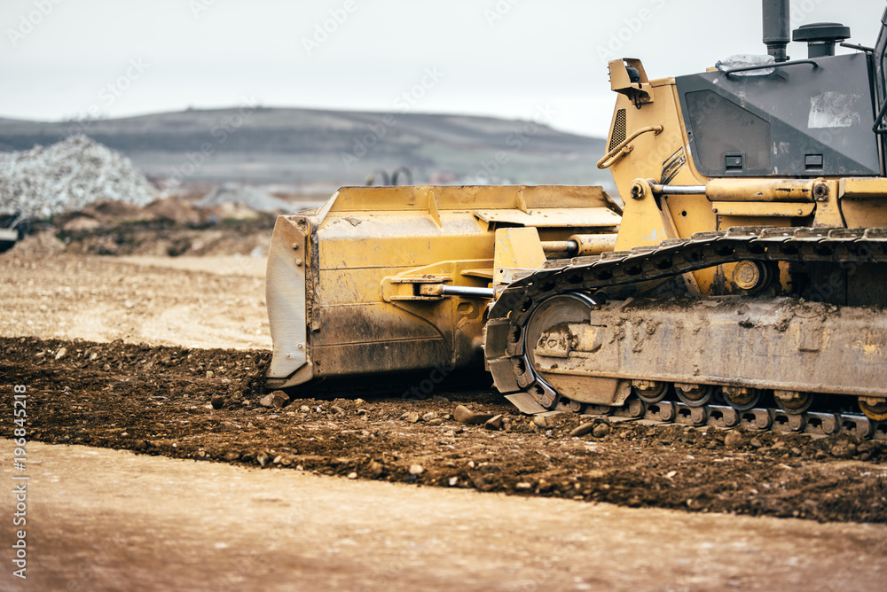 highway construction site development with bulldozer moving earth, soil and leveling ground highway construction site development with bulldozer moving earth, soil and leveling ground