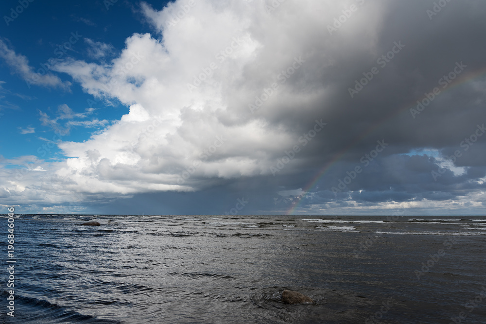 Clouds and rainbow over gulf of Riga, Baltic sea.