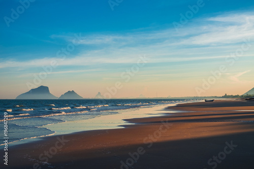 Beautiful evening sunset on the beach in Prachuab Khiri Khan, southen part of Thailandwith colorful sky, sand beach sea wave and mountain in the background. photo