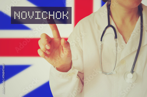 a young caucasian female doctor in a white robe against the background of the Great Britain flag points a finger at the inscription 