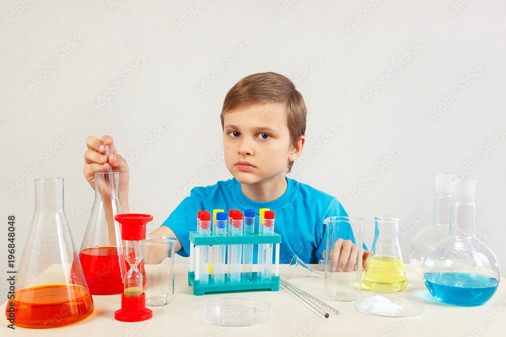 Little serious boy doing chemical experiments in the laboratory Little serious boy doing chemical experiments in the laboratory