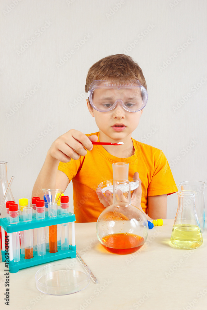 Little chemist in safety goggles studies chemical practice in the laboratory Little chemist in safety goggles studies chemical practice in the laboratory