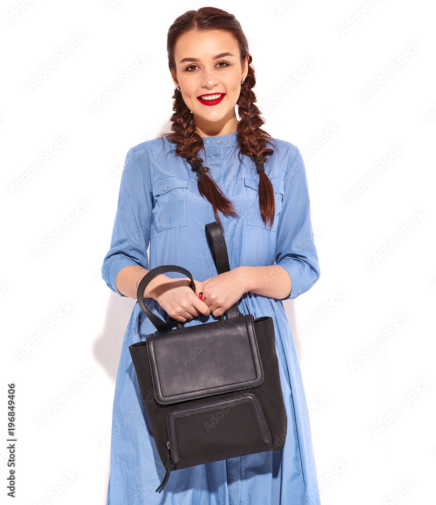 Portrait of young happy smiling woman model with bright makeup and red lips with two horns in hands in summer colorful blue dress and back pack isolated on white Portrait of young happy smiling woman model with bright makeup and red lips with two horns in hands in summer colorful blue dress and back pack isolated on white