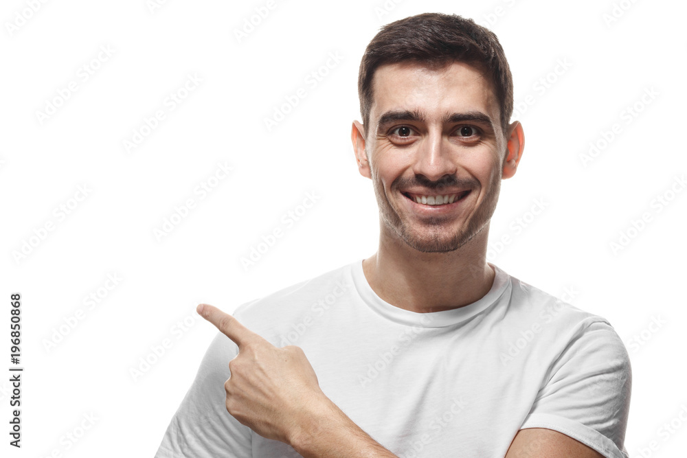 Handsome man in white t-shirt pointing left with finger isolated Handsome man in white t-shirt pointing left with finger isolated