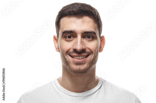 Close up headshot portrait of smiling handsome man in white t-shirt isolated