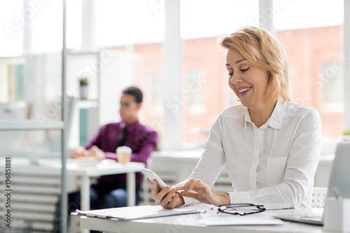 Businesswoman chatting with phone during coffee break