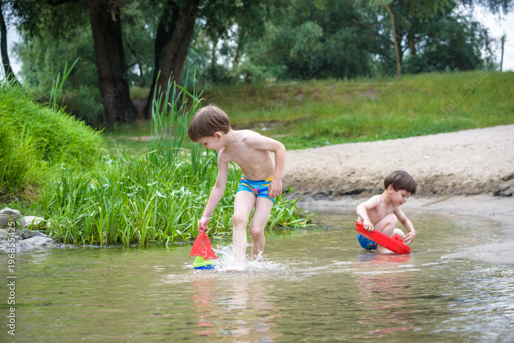 Fototapeta premium two blond brothers are having fun on the beach in a sunny summer day