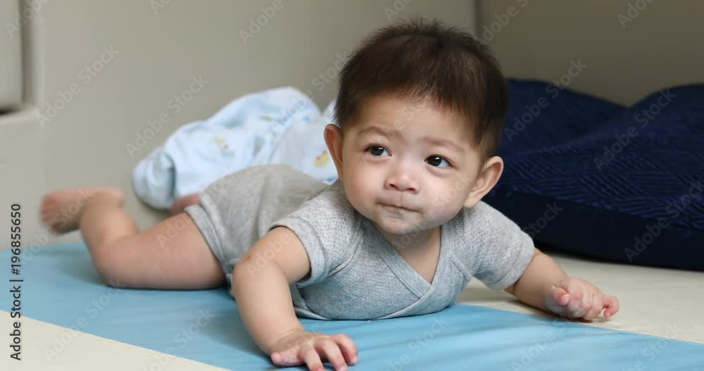 cute asian baby boy trying crawl on soft floor in nursery room cute asian baby boy trying crawl on soft floor in nursery room