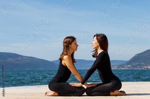 Two girls on the beach doing yoga, Montenegro