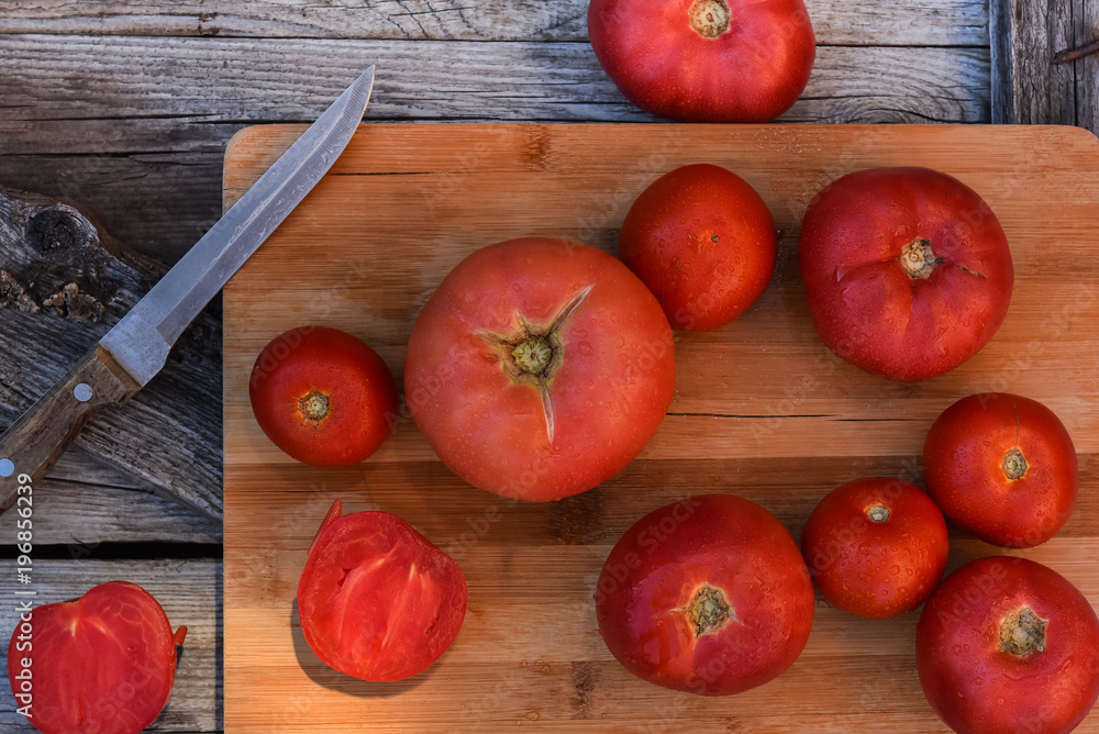 red tomatoes on the boards with a knife red tomatoes on the boards with a knife
