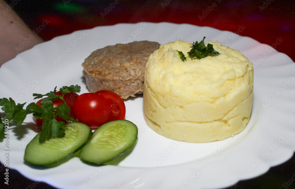 mashed potatoes with cutlets and vegetables in white plate