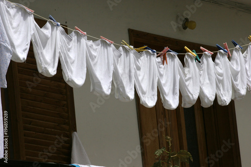 Underpants. The same white underpants hangs outside on a balcony after laundry. Identical underwear becomes dry outdoor. 