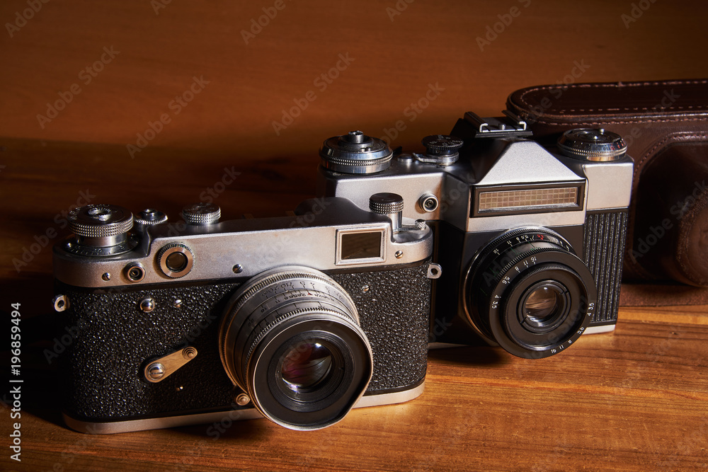 Two film cameras and a camera case made of leather that were made in the middle of the twentieth century