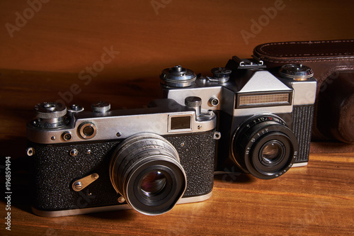 Two film cameras and a camera case made of leather that were made in the middle of the twentieth century