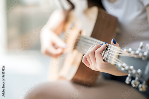 woman hands playing acoustic guitar