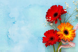 A wedding story or background Mother's Day. Three gerbera flowers  on a stone background or slate with copy space. Copy space, top view flat lay background.