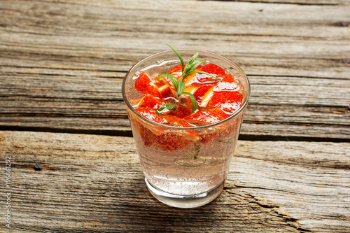 Red Cocktail with rosemary and blood orange pieces, selective focus photo