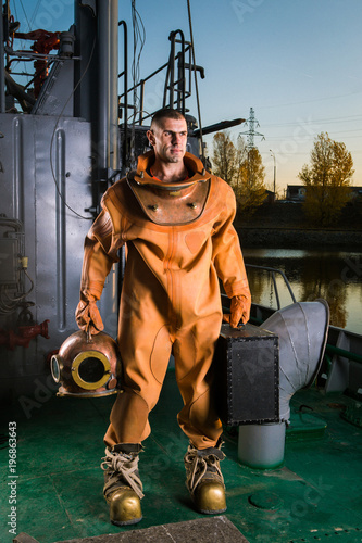 A brave diver in retro gear is standing on the deck of a ship
